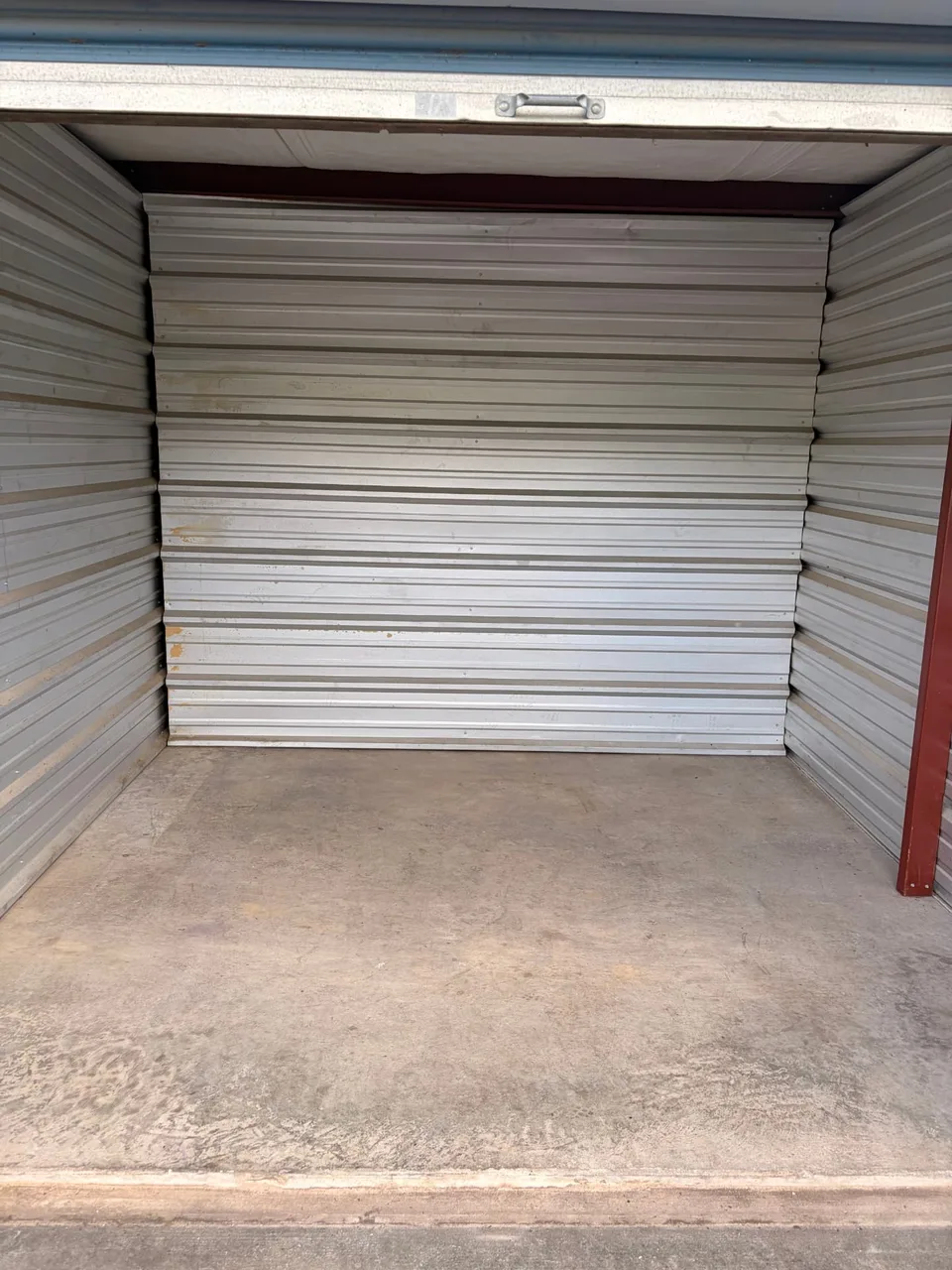Clean, empty 10x10 drive-up storage unit with swept concrete floor and open roll-up door in Staunton, VA