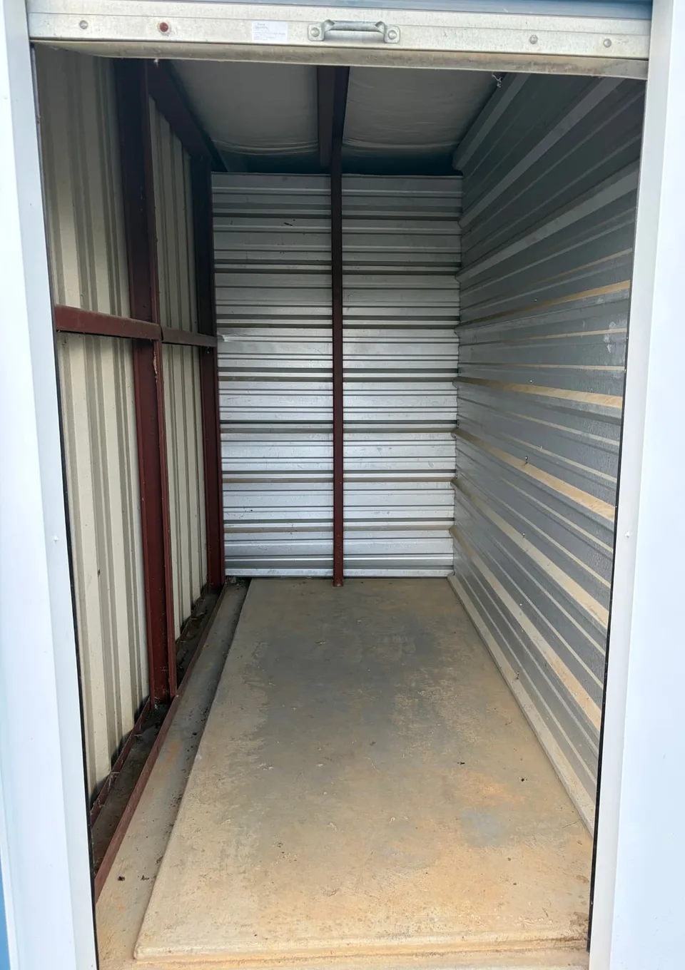 Inside a clean empty drive-up storage unit with steel walls and a full-width open roll-up door at American Mini Storage in Staunton, VA